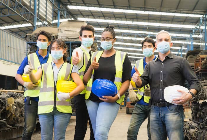 Overseas manufacturers: group of engineers wearing masks and doing the thumbs up