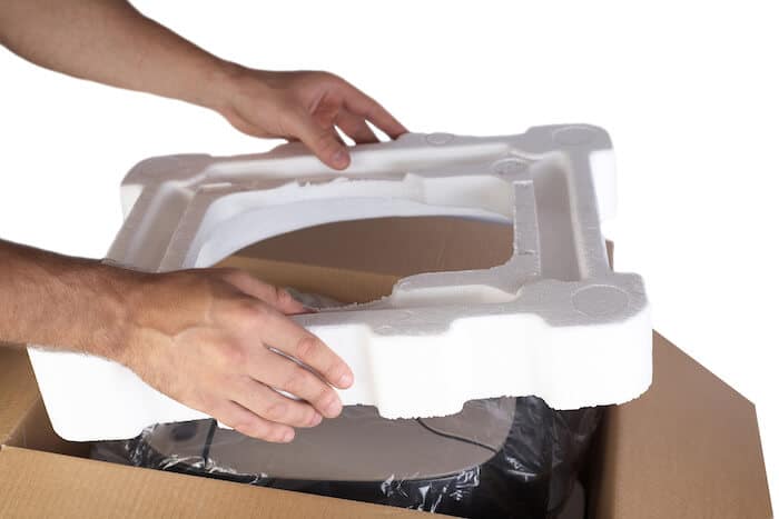 Person putting a styrofoam in a package