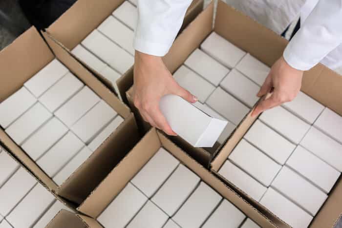 Product packaging: person putting packed products inside boxes