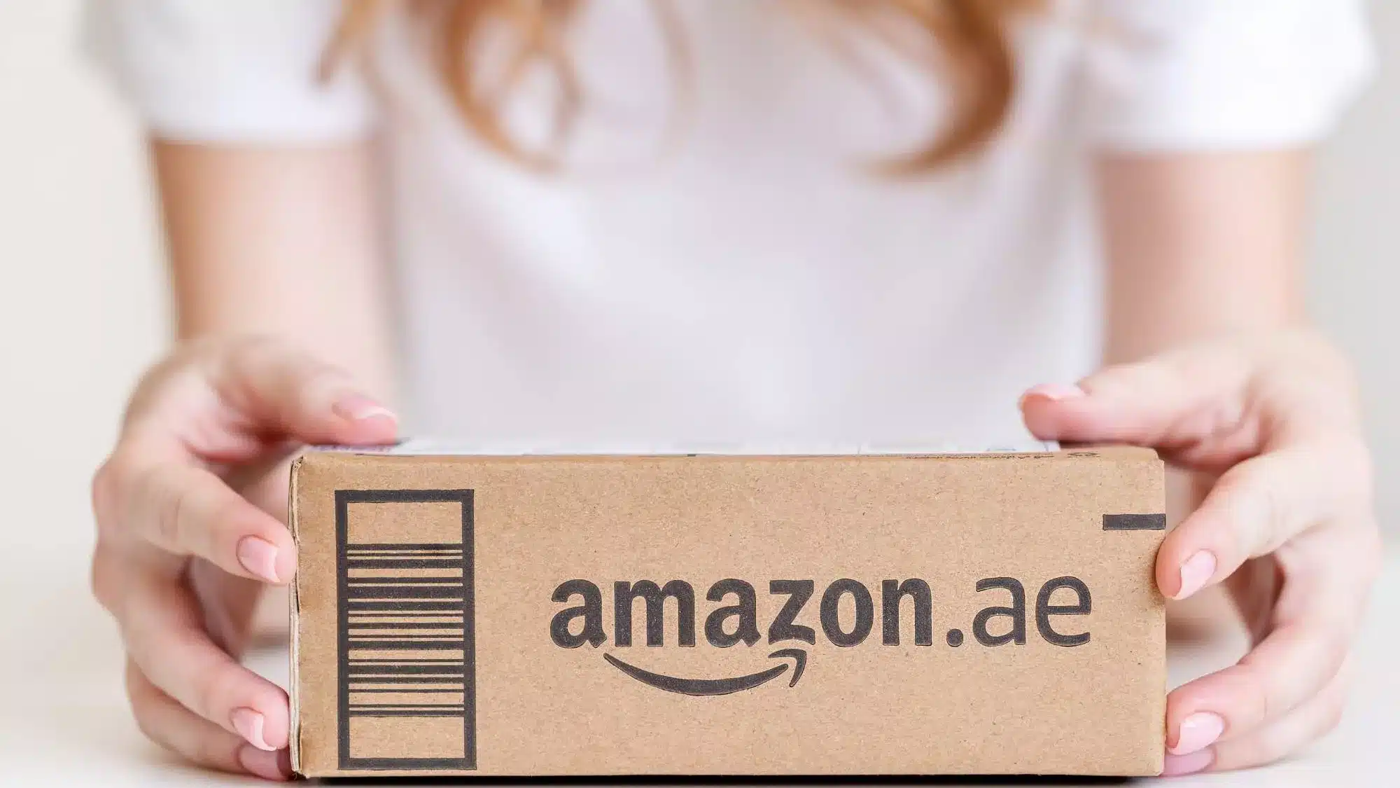 Woman holds box as she prepares her go-to-market strategy for Amazon