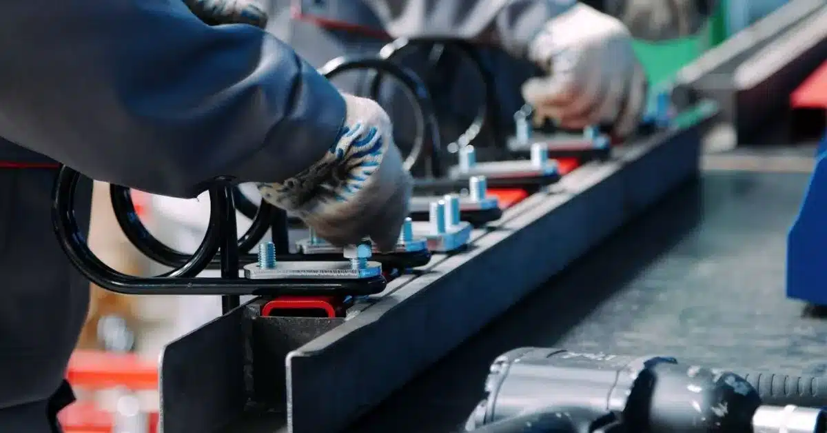 Factory workers assembling industrial components on a production line, representing the manufacturing capabilities and labor considerations evaluated when choosing between China and Mexico sourcing.