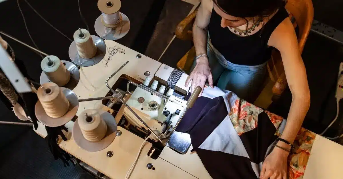 Designer sewing and assembling a product prototype in a workshop, illustrating the hands-on development and testing involved in custom product development before manufacturing begins.