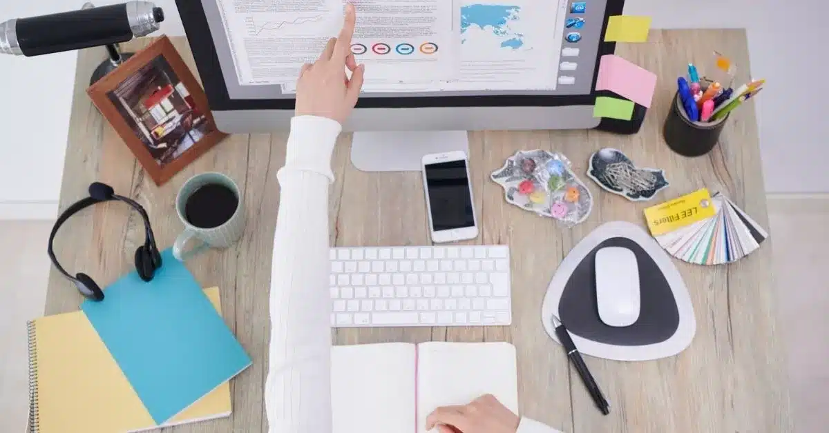 Product designer reviewing specifications and design documents at a workstation, representing the research, planning, and engineering phases of custom product development.
