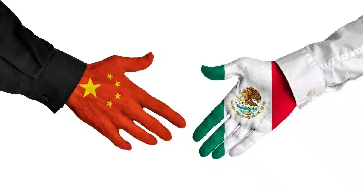 Hands painted with the Chinese and Mexican flags reaching toward each other, symbolizing the strategic choice between Chinese manufacturing, Mexican manufacturing, or a hybrid sourcing model for U.S.-bound products.