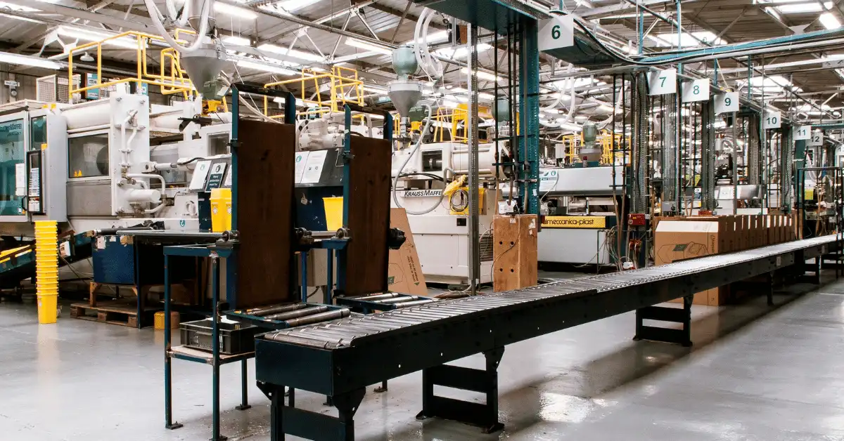 Manufacturing line with production equipment and conveyors representing factory due diligence before choosing a product manufacturing partner.