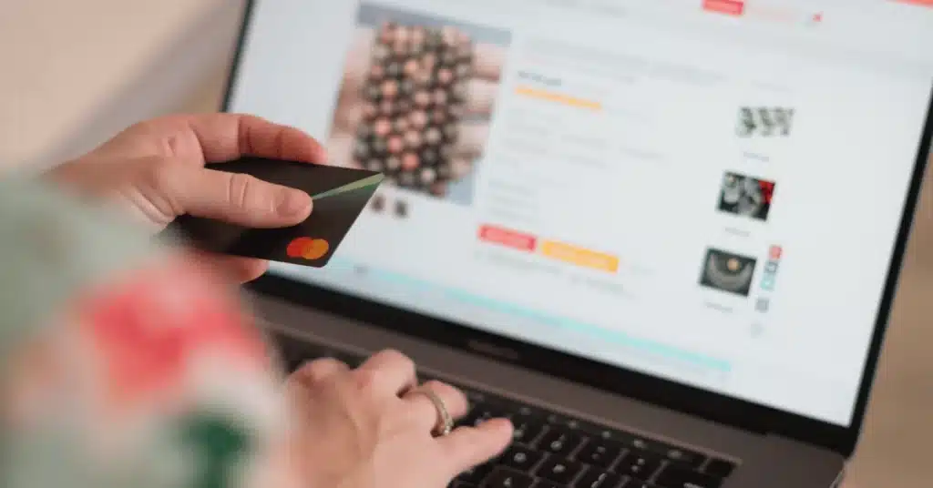 Person shopping online with a credit card, representing Amazon listing copy and product description updates.