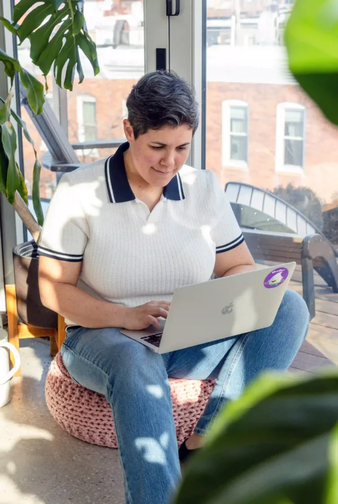 HoopDee founder Roxie Alsruhe working on a laptop with a HoopDee sticker