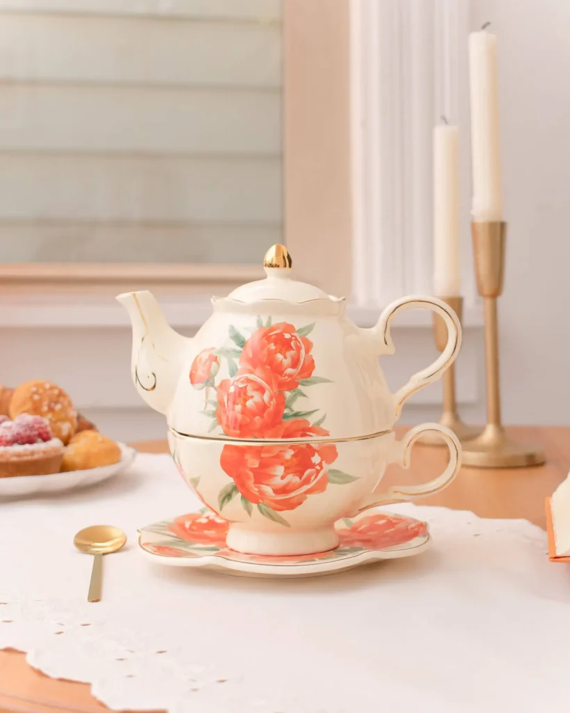 Peaceful Pursuits stacked tea-for-one set, teapot nested on the matching cup with a peony design and gold trim
