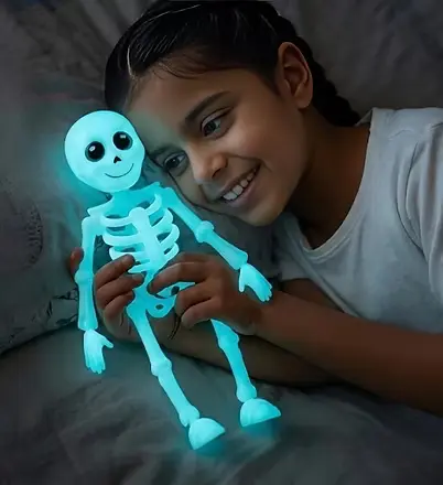 Child holding the Bones Is Back skeleton toy glowing blue-green in the dark