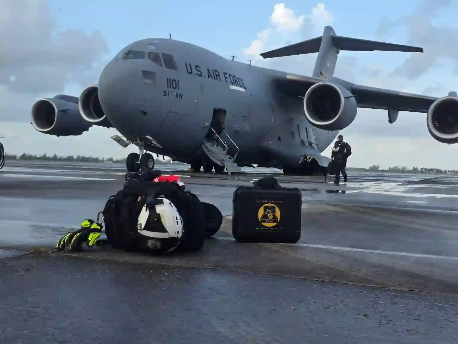 Search Grounds 72-Hour Cuban Coffee Kit case beside rescue gear on the tarmac in front of a US Air Force C-17